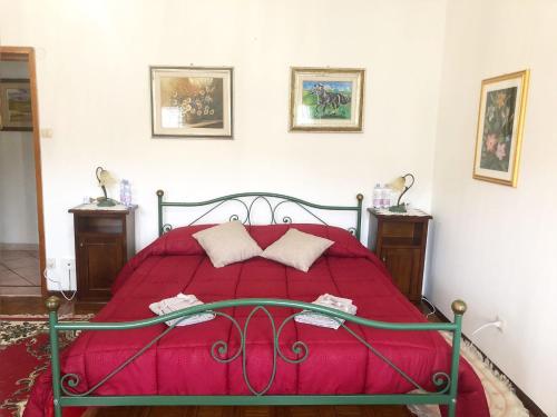 una camera con un letto con copriletto rosso di A casa di Maria a Ozieri
