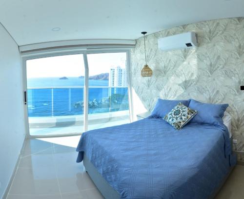 a bedroom with a blue bed and a large window at Luxury Aparment in Reserva del Mar in Gaira