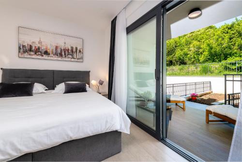 een slaapkamer met een bed en een glazen schuifdeur bij Apartment Mint in Dubrovnik
