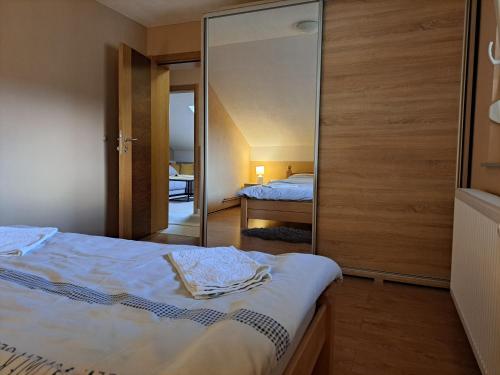 um quarto com uma cama e um espelho grande em Apartman Avram em Kotor-Varoš