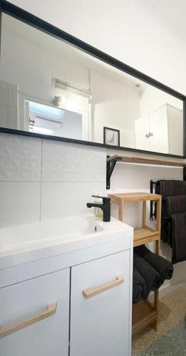 une salle de bain avec un lavabo et un miroir dans l'établissement Maison avec extérieur proche saint Guilhem le desert, à Saint-André-de-Sangonis