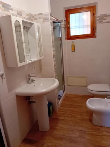 a bathroom with two sinks and a toilet at Luna e Mare in Cala Gonone