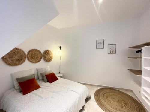 une chambre avec un lit blanc avec des oreillers rouges dans l'établissement Maison avec extérieur proche saint Guilhem le desert, à Saint-André-de-Sangonis