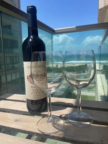 a bottle of wine and two wine glasses on a table at View of the Mediterranean Sea in Ashkelon