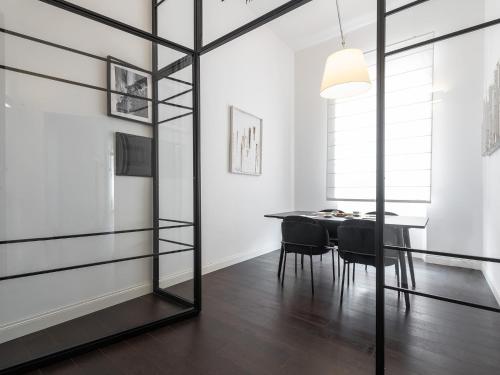 a dining room with a glass wall and a table at PLEY Cagliari Boutique Suites in Cagliari
