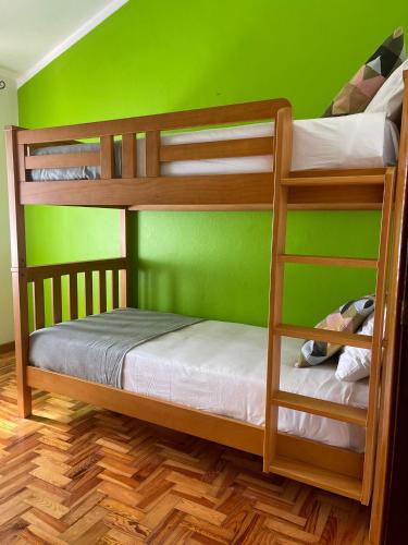 Valado dos FradesにあるPassagem Pro Marの緑の壁のドミトリールームの二段ベッド2台分です。