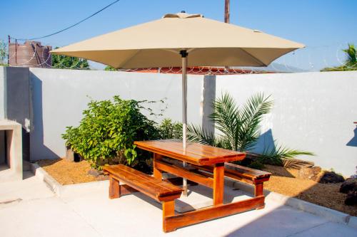 a picnic table with an umbrella and a bench at Home@Amalia’s in Rundu