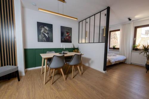 a dining room with a table and chairs and a bed at Design & Chill #Altstadt #Beamer in Lutherstadt Wittenberg