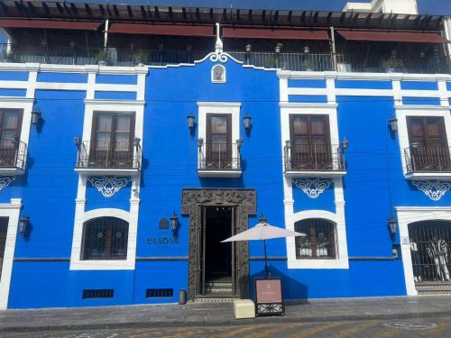 un bâtiment bleu avec un parasol devant lui dans l'établissement Casona Maria, à Puebla