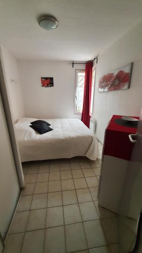 a bedroom with a bed and a red curtain at Jolie T2 N°1 Résidence du Vallons des Sources in Digne-les-Bains