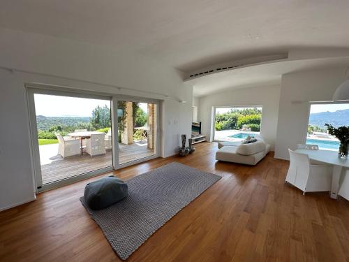 un ampio soggiorno con tavolo e divano di Villa with pool and panoramic view Costa Smeralda ad Abbiadori