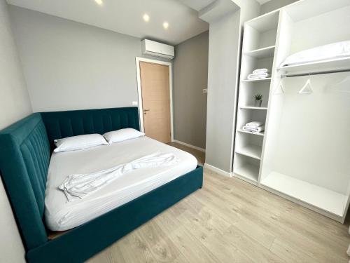 a bedroom with a blue bed and a closet at Belix Seaview Apartments in Durrës