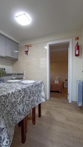 a kitchen with a table and a room with a bed at A Toca in Santana