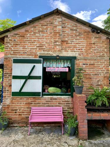 a pink bench sitting outside of a brick building at Campito Loving in Higuey