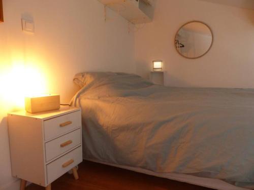 a bedroom with a bed and a white nightstand with a bed sidx sidx sidx at Logement idéal au centre-ville in Cavalaire-sur-Mer
