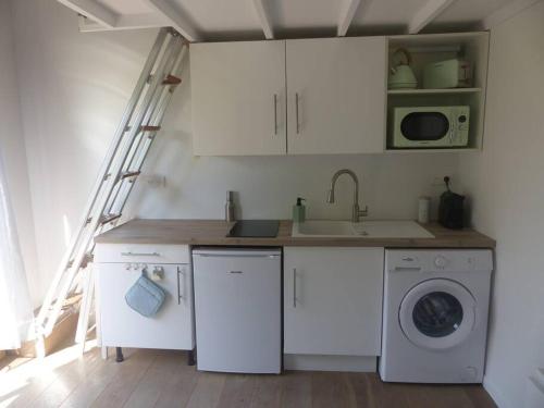 a kitchen with white cabinets and a washing machine at Logement idéal au centre-ville in Cavalaire-sur-Mer
