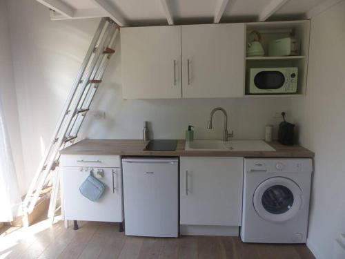 Una cocina con gabinetes blancos y lavadora. en Logement idéal au centre-ville, en Cavalaire-sur-Mer