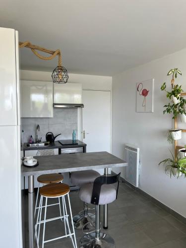 une cuisine avec un comptoir et des tabourets dans une pièce dans l'établissement Studio port camargues, au Grau-du-Roi