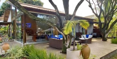 una casa con un patio con sillas azules y árboles en Lá em Casa - Guest House, en Barra Grande