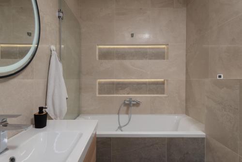 a bathroom with a tub and a sink and a mirror at Villa Voyage in Zadar