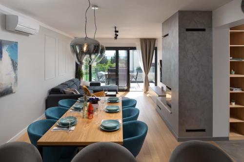 a living room with a wooden table and blue chairs at Villa Voyage in Zadar