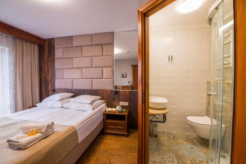 a bedroom with a bed and a shower and a toilet at Villa Akacja in Łeba