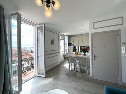 une cuisine et une salle à manger avec une grande fenêtre dans l'établissement SUNRISE BALCONY, à Cannes