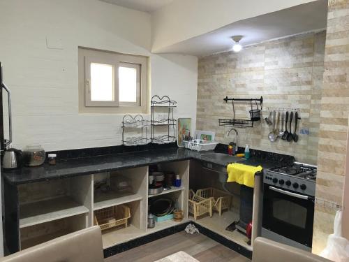 een keuken met een aanrecht en een fornuis bij Ageba Beach Marsa Matrouh Chalet 103 صف اول بحر in Zâwyet Umm el Rakham