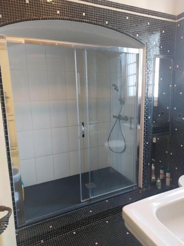 une douche avec une porte vitrée dans une salle de bain dans l'établissement Villa La Fontaine Sarlat La Caneda, à Sarlat-la-Canéda