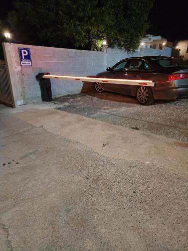 a car parked in a parking lot next to a wall at Ebra Lux Apartmani in Dobra Voda