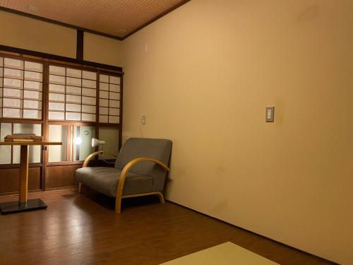 ein Wohnzimmer mit einem Stuhl und einem Tisch in der Unterkunft Hotel Lantern Gion in Kyoto