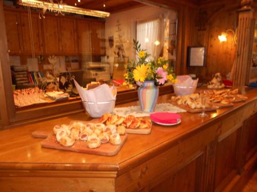 a kitchen counter with a bunch of pastries on at Hotel San Marco in Passo San Pellegrino