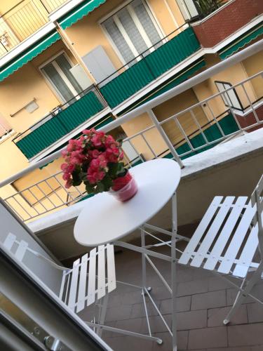 a table with a plant on a balcony with two chairs at Polly in Rapallo