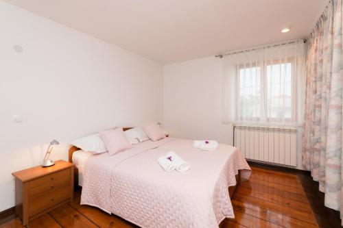 ein Schlafzimmer mit einem Bett, auf dem zwei Handtücher liegen in der Unterkunft Bepa in Supetar