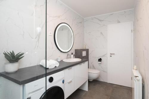 ein weißes Badezimmer mit Waschbecken und Spiegel in der Unterkunft Bepa in Supetar