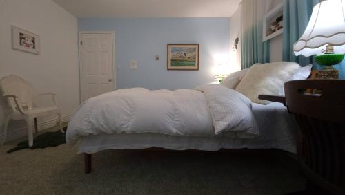 a bedroom with a white bed and a chair at sweet home in Richmond