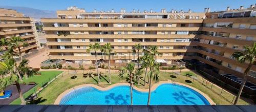 un gran edificio de apartamentos con piscina y palmeras en Ático SALINAS de Mar, en Roquetas de Mar