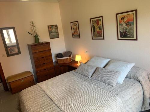 Apartamento céntrico في أفيليس: غرفة نوم بسرير وخزانة وصور على الحائط