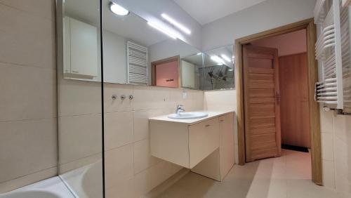a bathroom with a sink and a shower at Apartament Morski Pogórze in Pogórze