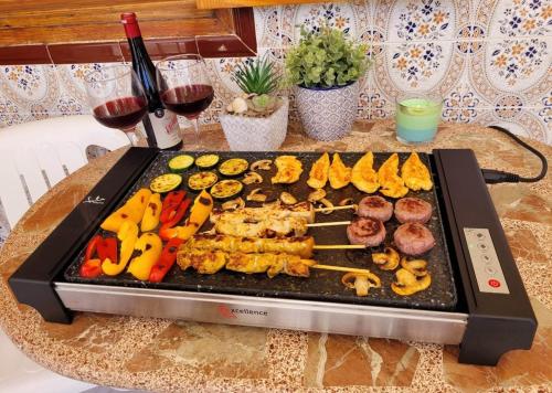 een grill met verschillende soorten voedsel op een tafel bij Apartamento Luna Blanca, La Mata, 300 m from the sea and sandy beach plus swimming pool in La Mata