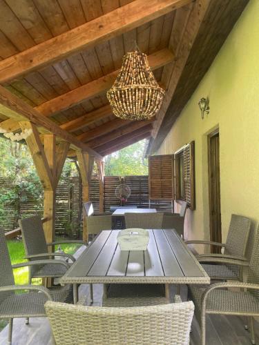 a patio with a table and chairs and a chandelier at Lake House Siófok in Siófok