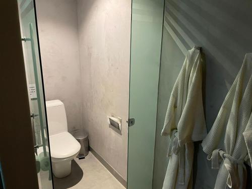 a bathroom with a toilet and a glass shower door at Union Motel (Adult Only) in Cabedelo