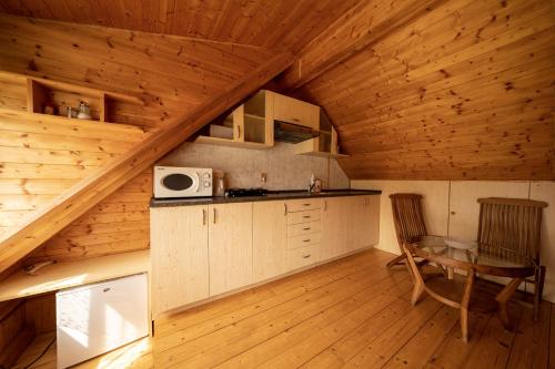 a kitchen in a log cabin with a table and a microwave at Strážné Chalet in Strážné