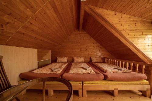 a bed in the attic of a wooden house at Strážné Chalet in Strážné