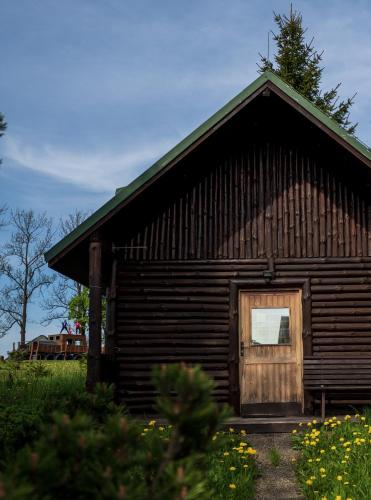 una cabaña de madera con una puerta en el costado en Strážné Chalet, en Strážné