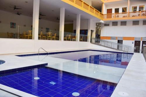 a swimming pool with blue tiles in a building at Hotel Neiva Plaza in Neiva