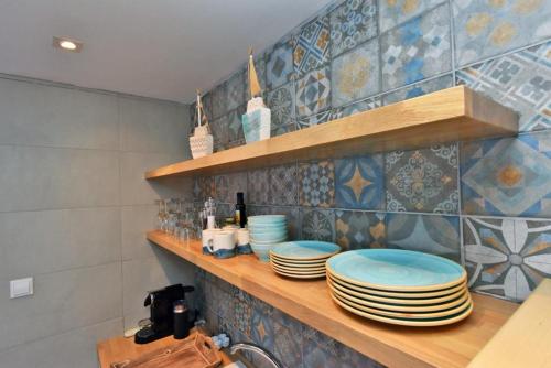 a kitchen with a counter with plates on a shelf at Afitos Sofia’s village in Afitos