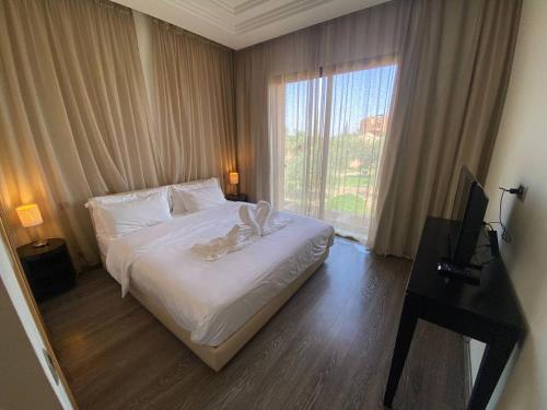 um quarto com uma cama com lençóis brancos e uma janela em Appartement Privé 1 Chambre Vizir Center Marrakech em Marrakech