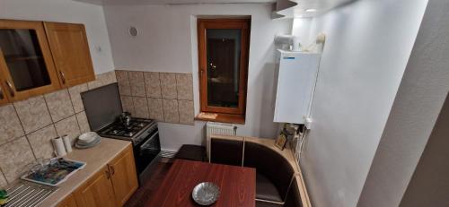 a small kitchen with a table and a refrigerator at ANASTASIA. in Tulcea