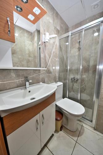 a bathroom with a toilet and a shower and a sink at GRAND Deniz Hotel in Istanbul